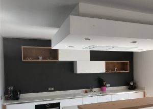 Réalisation d'une cuisine polymère blanc mat plan de travail céramique panneau bois chêne et hotte de plafond